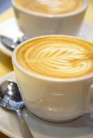 Foam in a cup of cappuccino on a light wooden table. photo