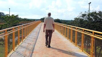 Mens wandelen aan de overkant een oprit van een nieuw gebouwd verhoogd voetganger loopbrug in Noord West Brazilië, Brazilië video