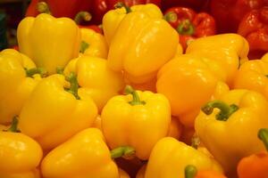 Fresh yellow and red organic bell peppers on the counter in the supermarket. photo