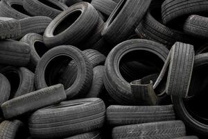 A pile of used car tires for recycling. Lots of old wheel tires in a landfill. photo