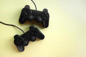 Two joystick gaming controlle on yellow background. photo