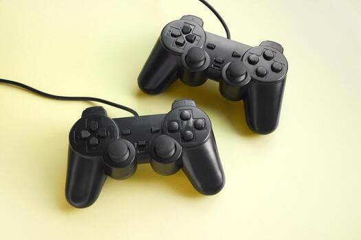 Two joystick gaming controller on yellow background. photo