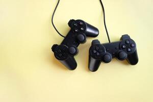 Two joystick gaming controlle on yellow background. photo