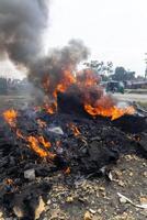 Large Pile of Black Smoke Next to Fire Hydrant, A photo of a significant amount of black smoke billowing next to a fire hydrant.