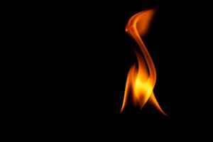 caliente llamas en un negro antecedentes. hermosa fuego de fuego en el oscuro. resumen de ardiente llamas y fumar. foto