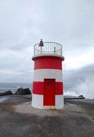 rojo y blanco faro en parte superior de muelle foto