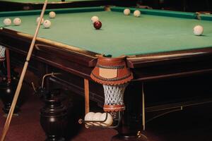 A pool table with balls that have already been played in the pool club.Playing billiards photo