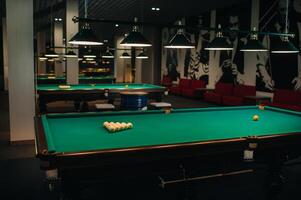 there are a lot of billiard tables with green surfaces and balls in the billiard club photo