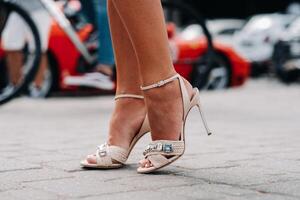 a woman in high-heeled shoes with artificial diamonds in the city. Beautiful feet in shoes close-up. photo