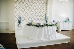 Wedding bride and groom table presidium decorated with a lot of flowers photo