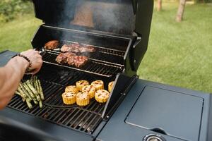 Cocinando carne y vegetales en un al aire libre parrilla foto