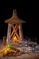 Cheese plate with a variety of snacks on the table with two glasses of wine by candlelight photo