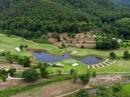 Aerial view of golf course with a rich green turf beautiful scenery. Sand bunkers at a beautiful golf course by the pond. photo