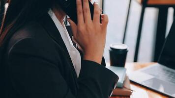 un mujer jugando un móvil teléfono por el ventana, un joven mujer de negocios y un joven ejecutivo fundado un puesta en marcha ese tiene consecuentemente hecho alto ganancias concepto de joven mujer de negocios y puesta en marcha compañía. video