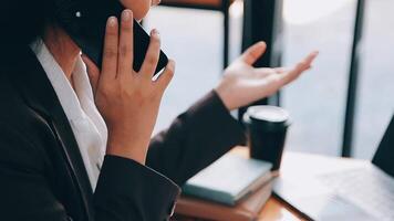 un mujer jugando un móvil teléfono por el ventana, un joven mujer de negocios y un joven ejecutivo fundado un puesta en marcha ese tiene consecuentemente hecho alto ganancias concepto de joven mujer de negocios y puesta en marcha compañía. video