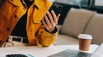 empresária asiática em terno formal no escritório feliz e alegre durante o uso de smartphone e trabalho video