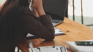 las mujeres asiáticas están estresadas mientras trabajan en una laptop, una mujer de negocios asiática cansada con dolor de cabeza en la oficina, se siente enferma en el trabajo, copia espacio video
