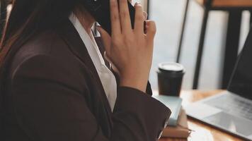 un' donna giocando un' mobile Telefono di il finestra, un' giovane donna d'affari e un' giovane esecutivo fondato un' avviare quello ha costantemente fatto alto profitti. concetto di giovane donna d'affari e avviare azienda. video