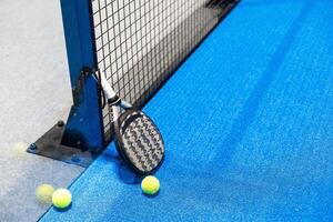 Paddle tennis racket, ball and net on the court photo