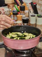 Sizzling Zucchini in a Skillet on a Gas Stove with Fire and Lid photo