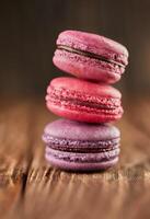 Fresco macarons de diferente colores y sabores en un de madera antecedentes foto