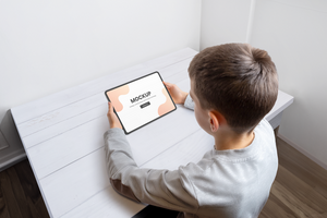garçon tenir tablette maquette pour Jeu ou app psd