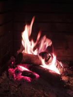 brillante llamas iluminar un ardiente fuego en un hogar foto