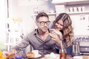 pretty young couple have fun in the kitchen while preparing breakfast photo