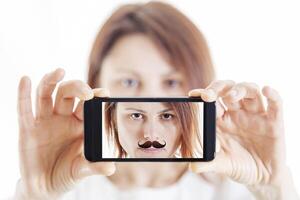 bonito mujer con Bigote tomando un selfie utilizando su teléfono inteligente foto