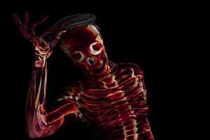 sensual woman dressed in a skeleton costume greets by raising her hat photo