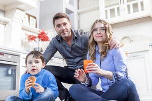 family relaxing on floor in the kitchen photo