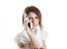 sexy mujer posando con pistola en blanco antecedentes foto