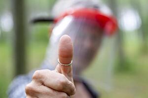 Experienced female lumberjack while showing thumb up photo