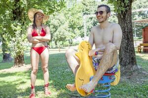 Young adult plays on a spring toy duck photo