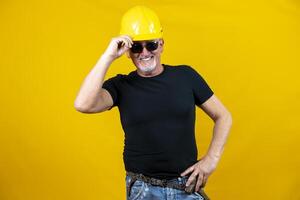 trabajador con casco y Gafas de sol aislado en amarillo antecedentes foto