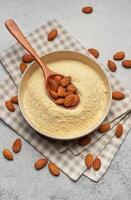 Fresh almond flour in a  bowl and almonds photo