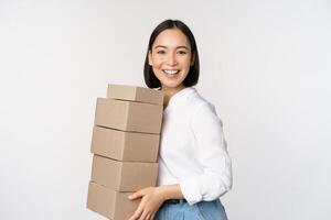 imagen de sonriente, contento asiático mujer participación pila de cajas, concepto de entrega, compras o negocio, blanco antecedentes foto