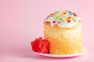 deliciosos pasteles de Pascua panettone decorados con cinta y flores sobre fondo rosa. foto