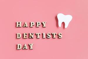 Mockup of tooth on pink background. Happy dentist day. Dental care concept. photo