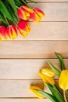 Yellow tulips on a light wooden background. Spring and holiday concept. photo