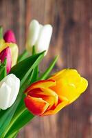 Yellow tulips on a light wooden background. Spring and holiday concept. photo