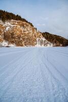 Winter view of the snow-covered nature in the mountains. Ural Mountains, Russia. Rock wall on a frozen river. Southern Urals, Chelyabinsk region photo