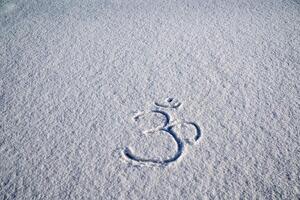 An inscription on the snow. Buddhist sign for meditation. Om shanti. Meditation, achieving Zen, a sense of calm and tranquility photo