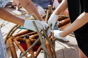 Processing of vines and branches for basket weaving. A person is dressed in special gloves that protect his hands. photo