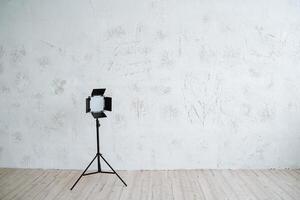 Studio light on the stand stands on a minimalist background. Equipment for photo studio, interior shooting.