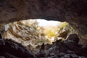 a mountain cave and a man photo