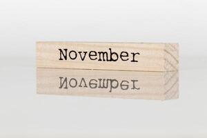 de madera cubo con el inscripción noviembre en un blanco antecedentes foto