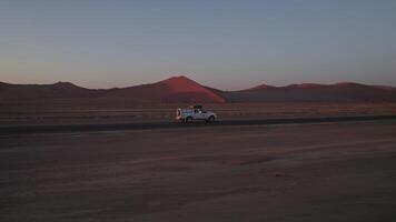 coche conducción mediante sossusvlei la carretera en Namibia en un puesta de sol video