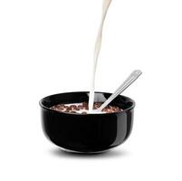 Pour a stream of milk on the chocolate flakes balls in a black bowl photo