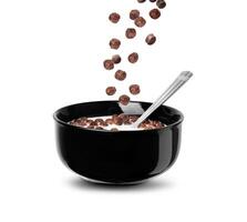 Falling chocolate cereal balls in milk in a black bowl isolated on a white background photo